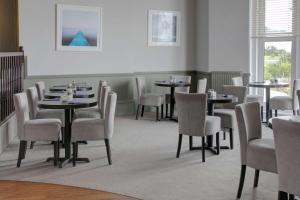 a dining room with tables and chairs in a room at Exmouth Beach Hotel in Exmouth