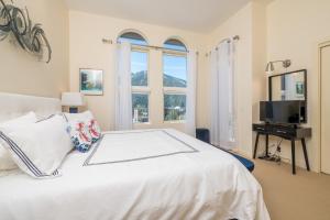 a bedroom with a white bed and a television at Leadville Penthouse #8 in Ketchum