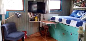 a bedroom with a bed and a chair and a tv at PENICHE ONDINE in Plombi&egrave;res-l&egrave;s-Dijon