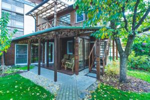 a house with a porch with a ladder at Namelis prie Magnolijos in Druskininkai