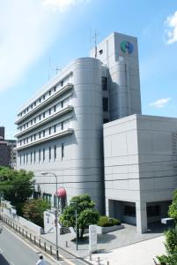 a large white building with a sign on it at Hotel International House Osaka in Osaka