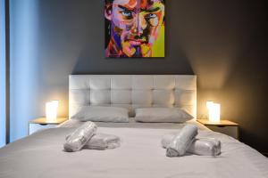 uma cama com duas almofadas com uma pintura em Thessaloniki Center Apartment em Tessalônica