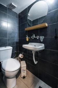 y baño con aseo, lavabo y espejo. en Thessaloniki Center Apartment en Tesalónica