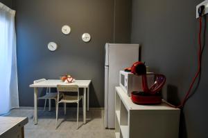 Thessaloniki Center Apartment في سلانيك: مطبخ مع طاولة وثلاجة بيضاء