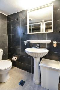 ein Badezimmer mit einem Waschbecken, einem WC und einem Spiegel in der Unterkunft Thessaloniki Center Apartment in Thessaloniki