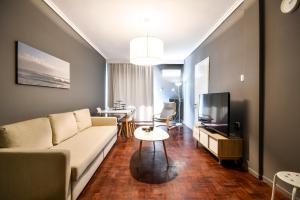 a living room with a couch and a tv at Thessaloniki Center Apartment in Thessaloniki