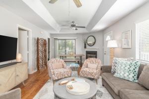 a living room with a couch and chairs and a tv at Shore to Please in Tybee Island