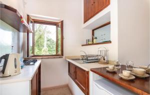 una cucina con pareti bianche, armadi in legno e una finestra di Amazing Apartment In Narni Tr With Kitchen a Capitone