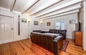 a living room with a leather couch and a television at Holten Seafishing in Torvikbukt