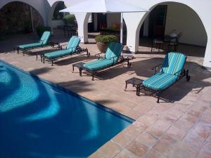 a group of chairs sitting next to a swimming pool at Nautilus Guest House in Hermanus