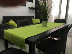 a table with a green table cloth on it with a couch at Luxury House in Letojanni