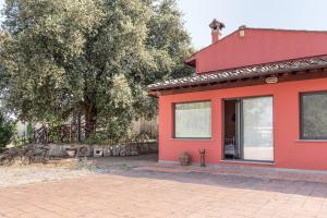 ein rotes Haus mit einem Baum davor in der Unterkunft Agriturismo Fattoria di Malavolta in Florenz
