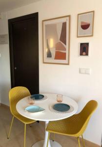 een witte tafel met twee stoelen in een kamer bij Apartmento studio boho a 1 minuto del puerto y la playa! in Jávea