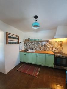 a kitchen with green cabinets and a stove at Casa Baptista in Monchique