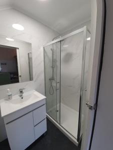 a white bathroom with a shower and a sink at Casa Baptista in Monchique +23 photos