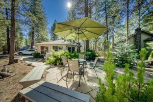 un patio con una mesa y una sombrilla en 9 Pine Mountain, en Sunriver