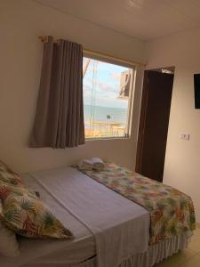 um quarto com uma cama e vista para o oceano em Pousada e Restaurante Império do Marisco em Maragogi