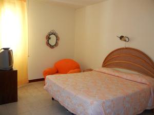 レッジョ・ディ・カラブリアにあるB&B La Pinetaのベッドルーム1室(ベッド1台、椅子、鏡付)