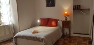 a small bedroom with a bed with red pillows at La maison de Louise in Fontenay-le-Comte