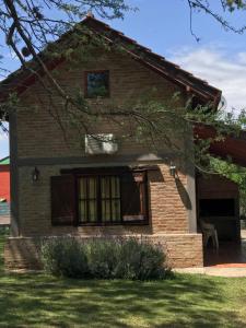 una casa de ladrillo con ventana y patio en Cabañas Luz de Luna en Santa Rosa de Calamuchita