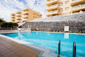 a swimming pool in front of a building at Palm Mar de LUX A26 in Palm-mar
