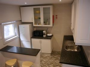 eine kleine Küche mit einem weißen Kühlschrank und einer Spüle in der Unterkunft OPO Downtown - cozy apartment @Oporto city center in Porto