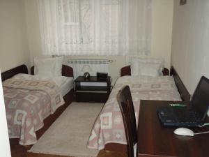ウッチにあるLuksusowe Apartamenty Łódźのベッドルーム1室(ベッド2台、ノートパソコン付きのデスク付)