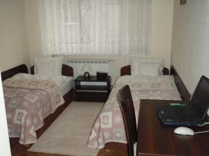 a bedroom with two beds and a desk with a laptop at Luksusowe Apartamenty Łódź in Łódź