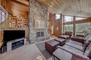 a living room with a stone fireplace and a tv at 21 Poplar in Sunriver