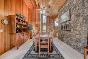 a dining room with a table and a stone wall at 21 Poplar in Sunriver