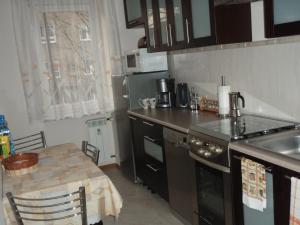 a kitchen with a stove and a table with a tableablish at Luksusowe Apartamenty Łódź in Łódź