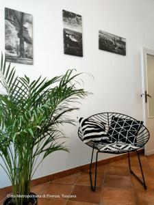 uma cadeira preta e branca sentada ao lado de uma planta em Nice & Roomy Apartment behind the Uffizi Museum em Florença