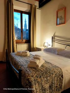 - une chambre avec un lit et des serviettes dans l'établissement Cozy 4th and top floor apartment, à Florence