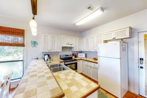 a kitchen with white cabinets and a white refrigerator at Molokai Villas 7B in Pensacola