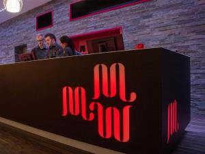 a sign for a bar with people standing behind it at Motel L Hammarby Sjöstad in Stockholm