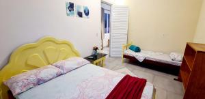 a bedroom with two beds and a yellow headboard at Morada das Orquídeas in Guarda do Embaú