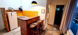 a small kitchen with a counter and a refrigerator at Morada das Orquídeas in Guarda do Embaú