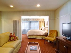 カーメルにあるWayside Innのベッドとテレビが備わるホテルルームです。