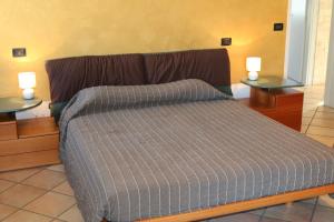 um quarto com uma cama com duas mesas de cabeceira e duas mesas em Apartment in Lazise - Gardasee 41950 em Lazise