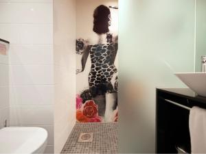 a bathroom with a shower with a picture of a woman at Motel L Hammarby Sjöstad in Stockholm