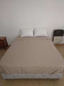 a large white bed with two pillows on it at monoambiente malbec ubicacion privilegiada no mascotas in Mendoza