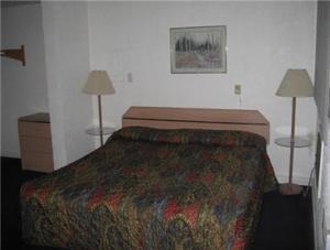 a hotel room with a bed and two lamps at Hub Motel in Redmond