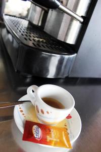 uma xícara de café sentado em um prato em um balcão em Hotel Palinuro em Palinuro