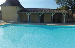 a large blue swimming pool in front of a house at Stunning Apartment In Limeuil With 2 Bedrooms in La Terrasse