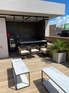 eine Terrasse mit einer Tischtennisplatte und Stühlen in der Unterkunft Studio Vivendas do Mar in João Pessoa