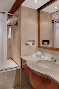 uma casa de banho com um lavatório e um espelho em Holiday Inn Manila Galleria, an IHG Hotel em Manila