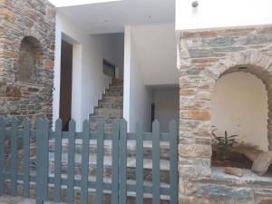 uma cerca em frente a uma casa com uma escada em Amoraninew em Batsi
