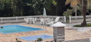 un patio con tavolo, sedie e piscina di Pousada Pedacinho do Ceu - casa inteira a Cunha