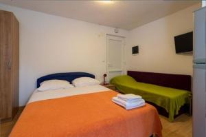 ein Hotelzimmer mit 2 Betten und einem TV in der Unterkunft Apartments Mir - family apartments with garden terrace in Zaton