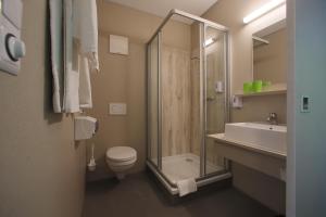 La salle de bains est pourvue d'une douche, de toilettes et d'un lavabo. dans l'établissement Smart Motel, à Gars am Kamp